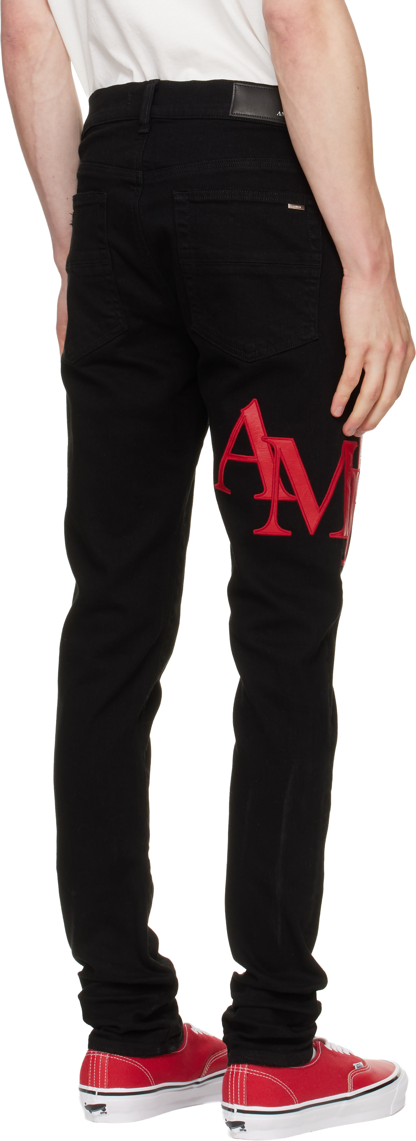 AMIRI: Black Staggered Logo Skinny Jeans | SSENSE